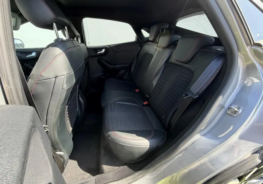 Vue intérieure côté droit de la banquette arrière noire avec surpiqûres rouges du Ford Puma gris métal 2020 ST-Line X.