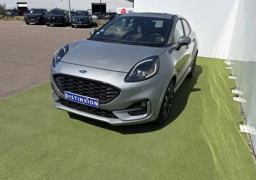 Ford Puma gris métal vue 3/4 avant droit avec calandre noire et jantes alliage noires.