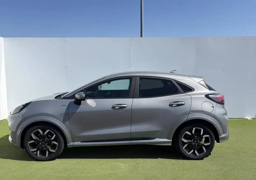 Vue latérale droite du Ford Puma gris métal, mettant en valeur ses jantes alliage noires et ses vitres arrière surteintées.