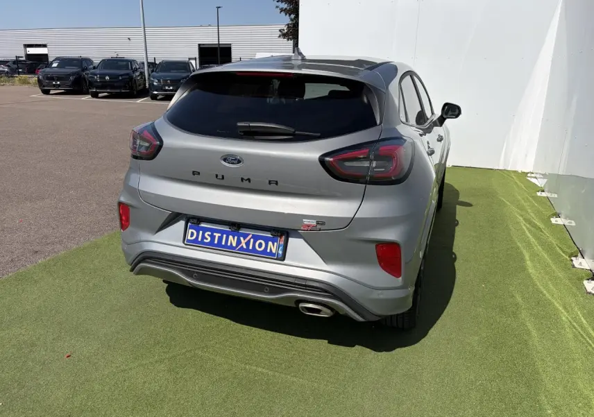 Vue 3/4 arrière droite d'une Ford Puma gris métal finition ST-Line avec feux LED et sortie d'échappement chromée visible.