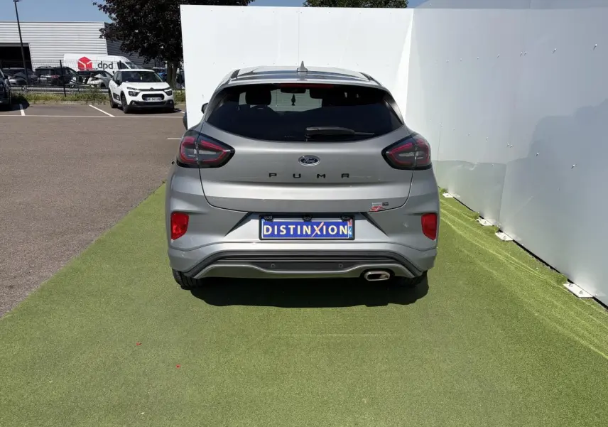 Vue arrière d'un Ford Puma gris métal avec logo ST-Line et sortie d'échappement chromée visible.