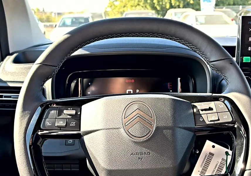 Volant cuir multifonction de Citroën Berlingo 2026, vue frontale rapprochée sur le tableau de bord noir.