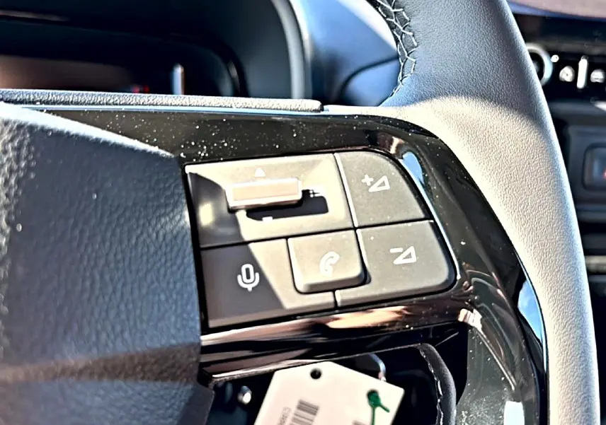 Gros plan sur les commandes vocales et téléphoniques du volant cuir noir du Citroën Berlingo 2026 intérieur.