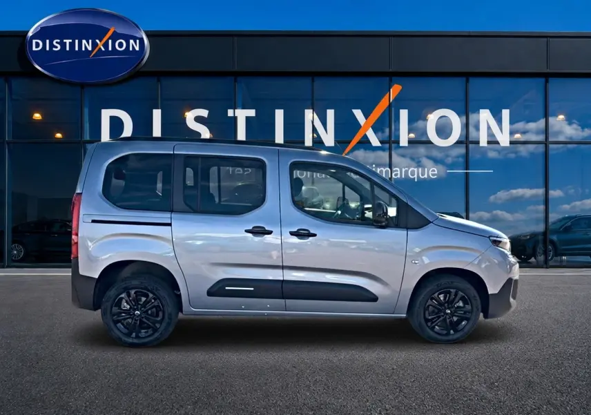 Profil droit du Citroën Berlingo N1 1.5 BlueHDi 130 gris acier avec jantes noires et barres de toit visibles.