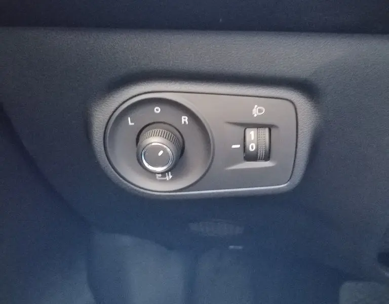 Gros plan sur les commandes de réglage des rétroviseurs et de l’éclairage, intérieur noir du MG ZS 1.5 l Hybrid+ 2026.