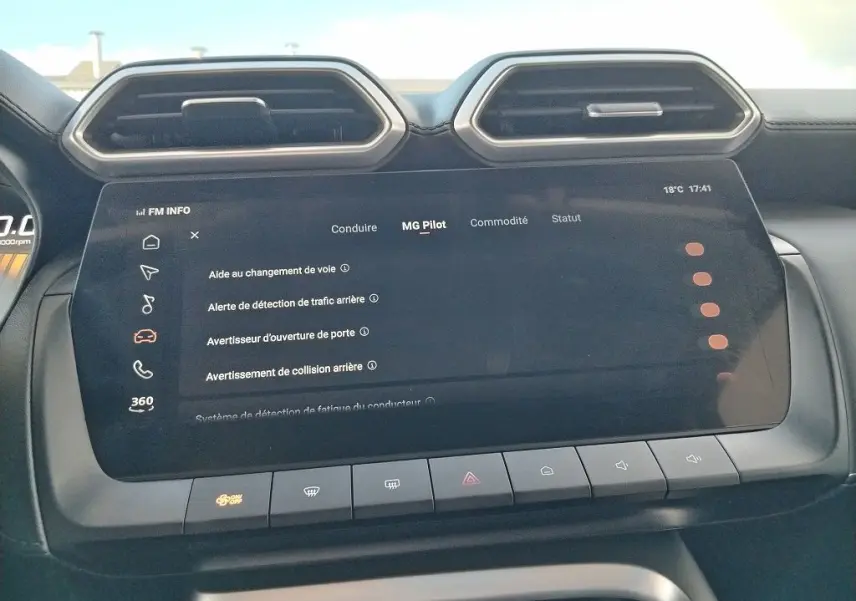 Vue rapprochée de l'écran tactile central du MG Motor ZS 1.5 l Hybrid + 197 Luxury en Cosmic Silver, affichant les options d'aide à la conduite.