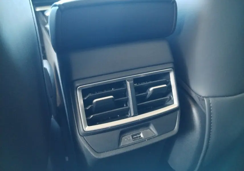 Gros plan sur la sortie d'air arrière avec port USB du MG MOTOR ZS 1.5 l Hybrid + 197 LUXURY, intérieur noir.