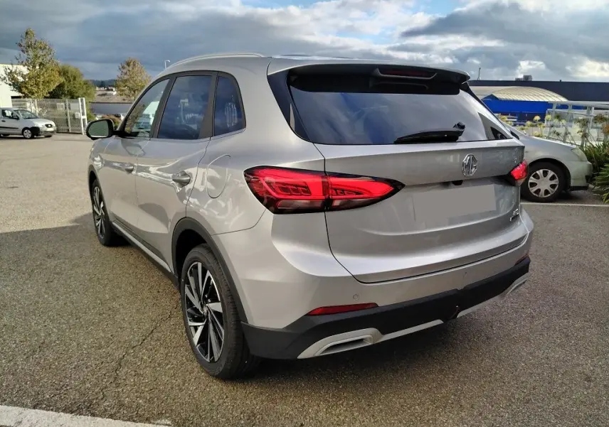 Vue 3/4 arrière droite du MG ZS 1.5 l Hybrid Cosmic Silver, avec feux arrière LED et jantes alliage noires.