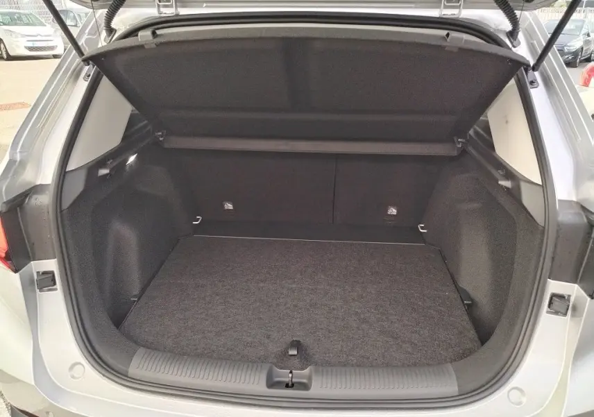 Coffre ouvert vu de l'arrière du MG MOTOR ZS 1.5 l Hybrid + 197 LUXURY en couleur Cosmic Silver, intérieur noir.