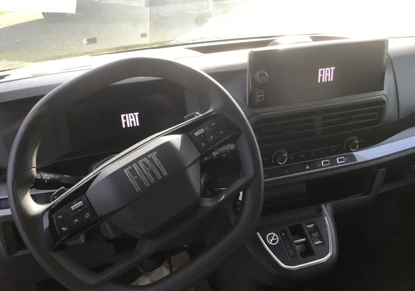 Vue intérieure du tableau de bord du Fiat Scudo Fourgon 2024, avec volant multifonction et écran tactile affichant le logo FIAT.