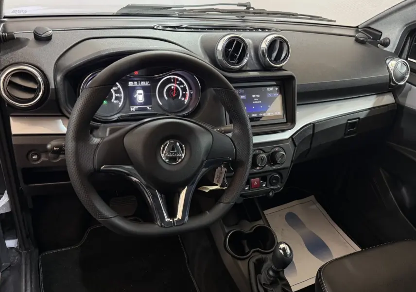 Vue intérieure centrée sur le tableau de bord et le volant de l'AIXAM AMBITION 0.5 CROSSOVER PREMIUM avec écran tactile et commandes.