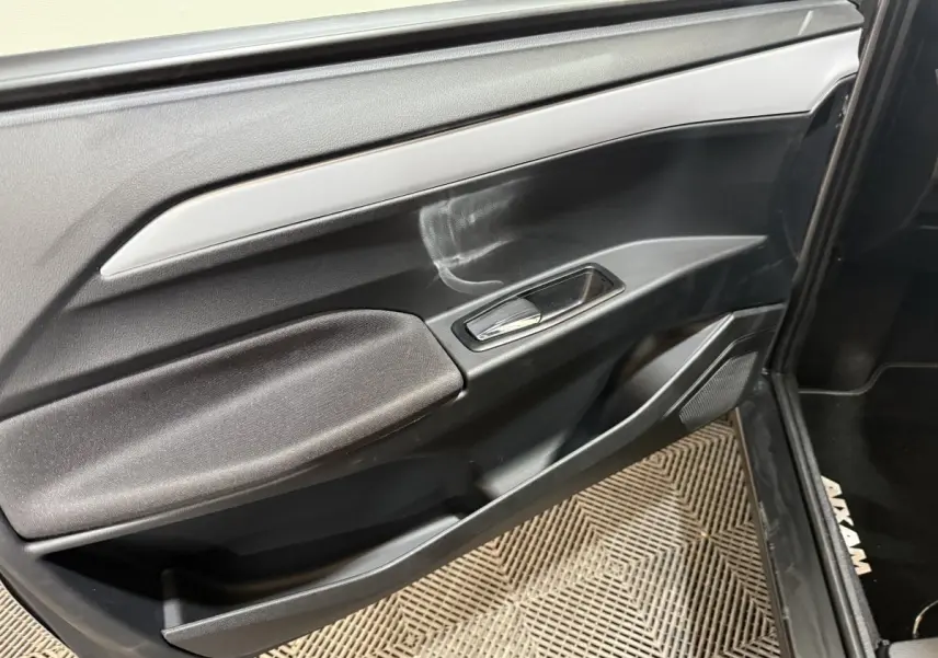 Détail de la porte côté conducteur de l’AIXAM Ambition 0.5 Crossover Premium 2026 en gris foncé, avec poignée et haut-parleur intégrés.