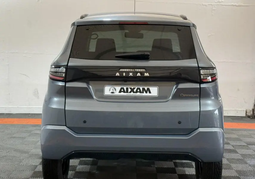 Vue arrière d'une Aixam Ambition 0.5 Crossover Premium gris foncé avec logo et feux horizontaux distinctifs.