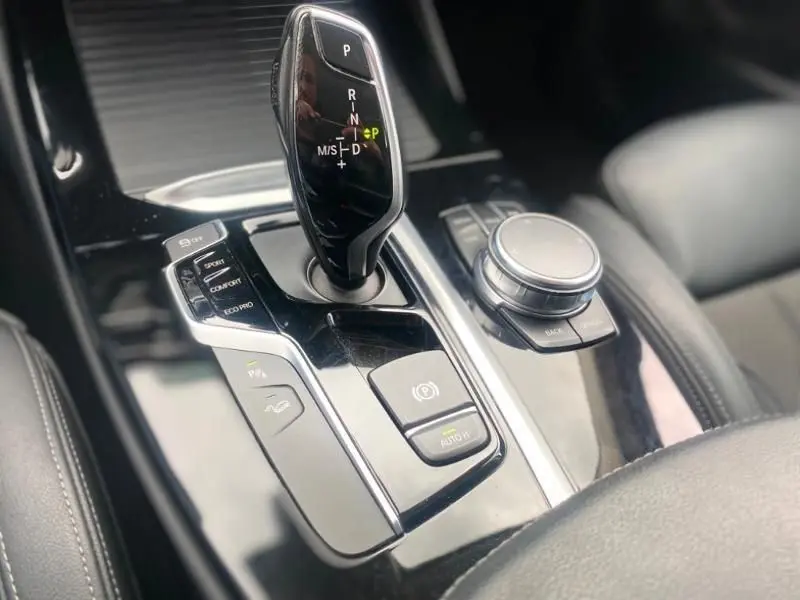 Gros plan sur la console centrale de la BMW X3 X-DRIVE 20 DA 2018, montrant le levier de vitesses automatique et les commandes de mode de conduite.