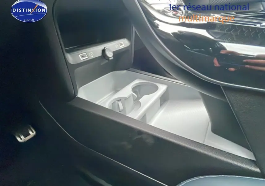 Gros plan sur le rangement central avant et porte-gobelets du Citroën C5 Aircross bleu, intérieur noir et gris.