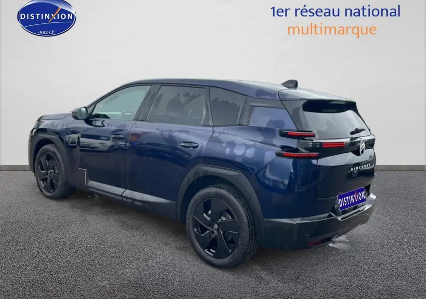 Vue 3/4 arrière droite d'un Citroën C5 Aircross bleu 2026 avec jantes noires et feux arrière LED horizontaux.