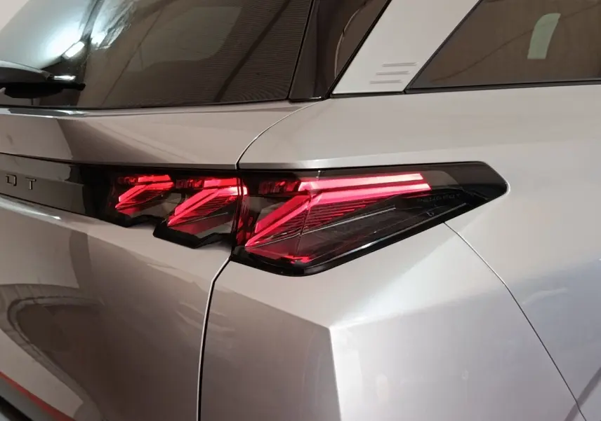 Feu arrière droit allumé sur Peugeot 5008 gris clair, vue rapprochée du côté arrière droit du véhicule.