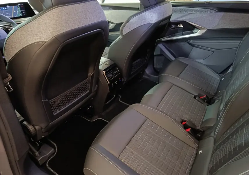 Vue intérieure arrière côté droit du Peugeot 5008 gris clair, montrant les sièges en tissu et cuir avec coutures contrastées.