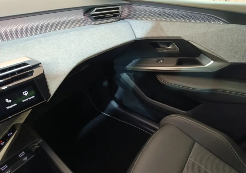 Vue intérieure côté passager du Peugeot 5008 gris clair 1.6 PHEV 195 E-DCS7 GT, avec tableau de bord et garnitures tissu clair.