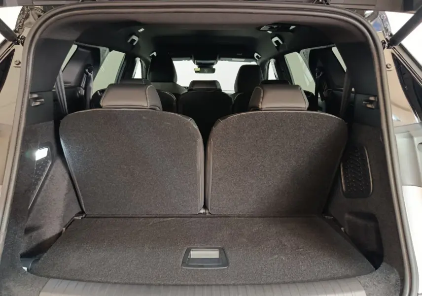 Coffre ouvert vue arrière du Peugeot 5008 gris clair avec sièges de troisième rangée relevés.