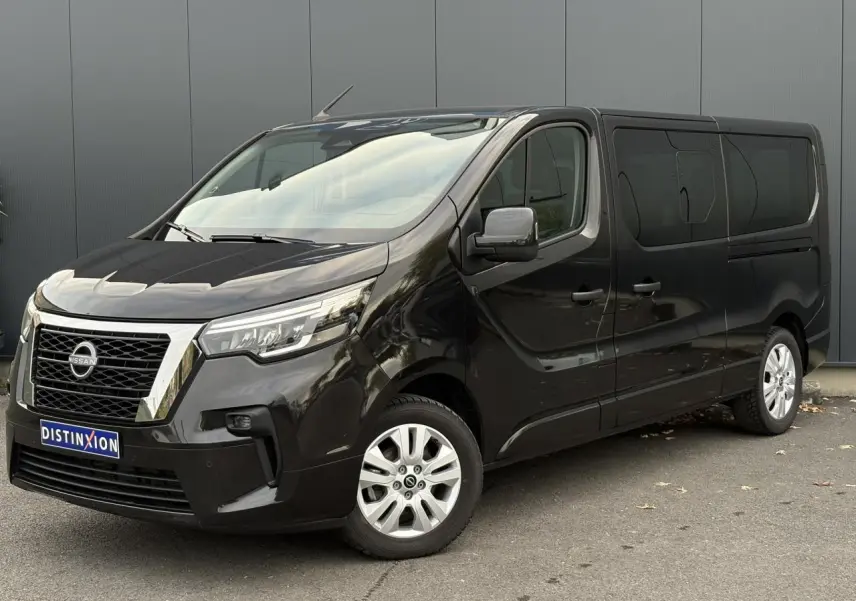 Nissan Primastar Combi noir métal vu en 3/4 avant droit avec hayon arrière vitré et jantes alliage 17 pouces.