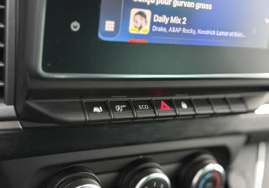 Boutons de commande de la console centrale du Nissan Primastar Combi noir métal, avec fonction éco et alerte.