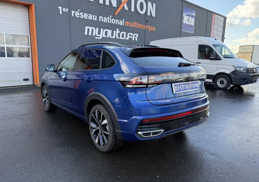 Volkswagen Taigo bleu récif métallisé en 3/4 arrière droit, avec jantes noires brillantes et feux arrière LED.