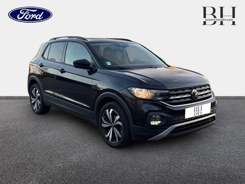 Volkswagen T-Cross noir intense nacré vu en 3/4 avant droit avec jantes alu bicolores et calandre chromée.