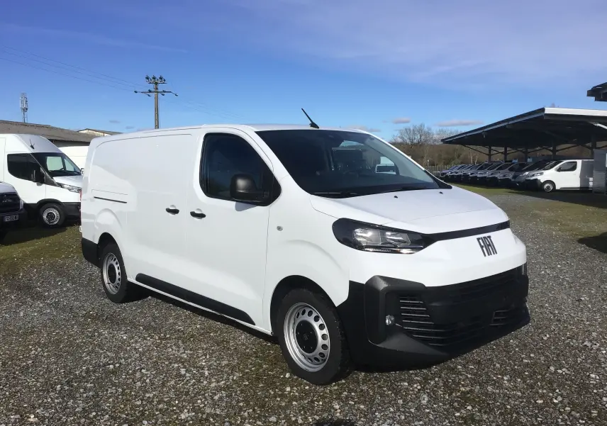 Vue 3/4 avant droite d’un FIAT Scudo Fourgon blanc 2024 avec garde au sol réhaussée et pare-chocs noirs.