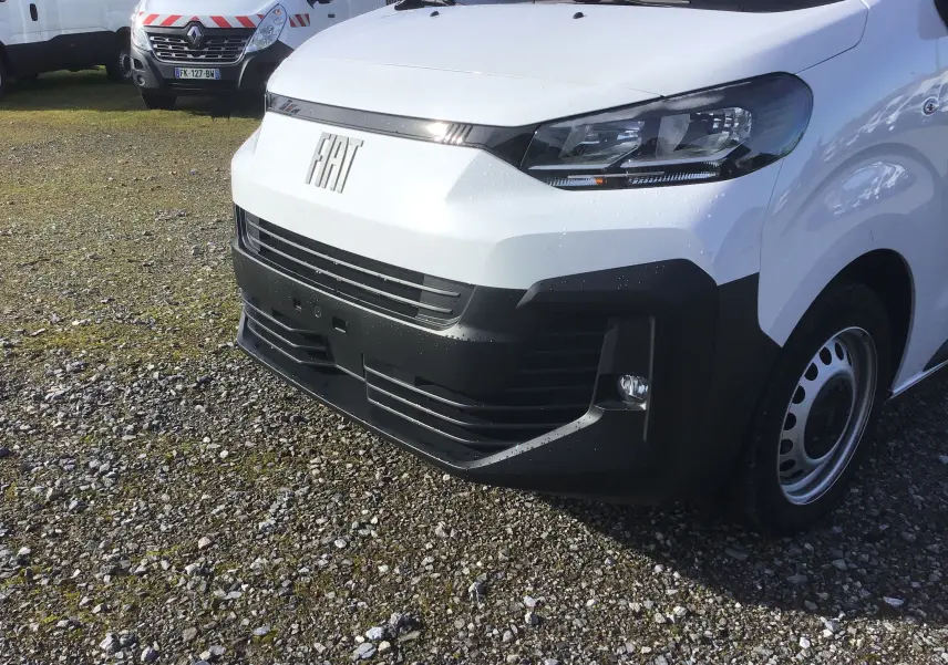 Vue 3/4 avant droit d’un FIAT Scudo Fourgon blanc 2024 avec pare-chocs noir et calandre épurée.