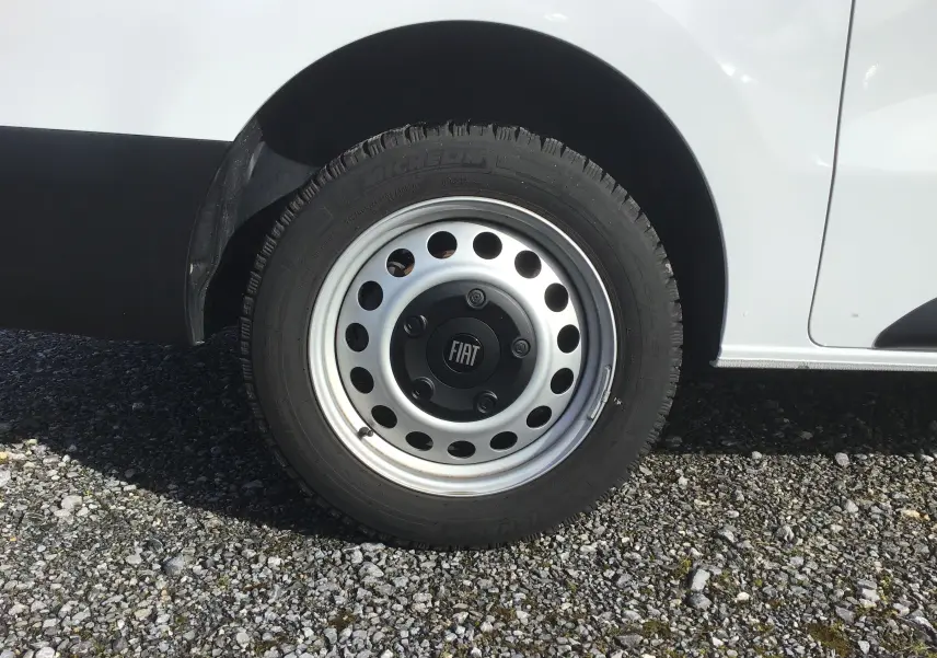 Gros plan sur la roue avant droite du FIAT Scudo Fourgon blanc 2024 avec jante acier et logo central FIAT.