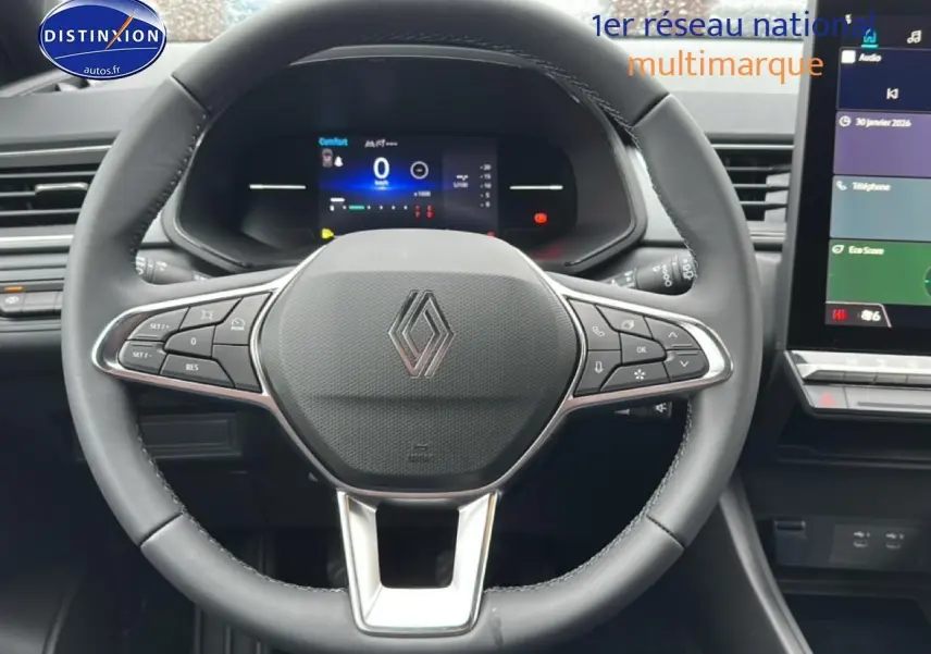 Vue rapprochée du volant multifonction noir du Renault Captur 2025 avec tableau de bord numérique et écran tactile.