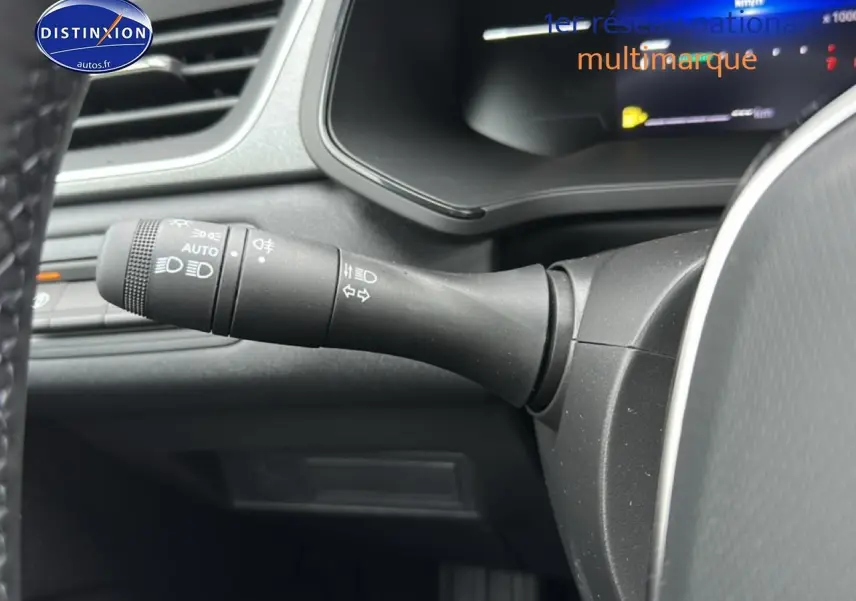 Gros plan sur la commande des phares et clignotants à gauche du volant dans l’habitacle gris du Renault Captur gris rafale.