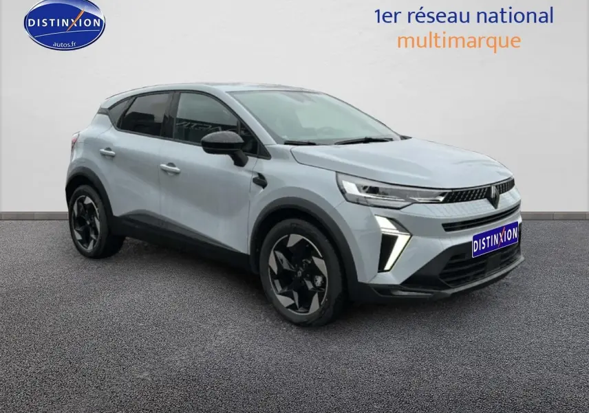 Renault Captur gris rafale en 3/4 avant droit, avec jantes noires et feux LED distinctifs allumés.
