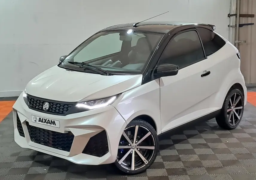 Vue 3/4 avant d'une Aixam Ambition 0.5 City Coupe GTI blanche avec toit noir et jantes alliage noires.