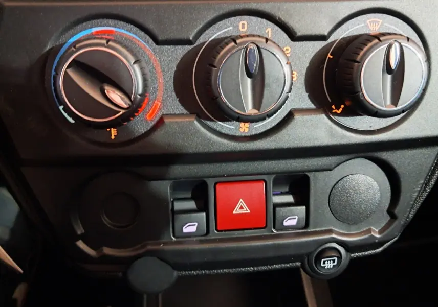 Détail du tableau de bord de l'AIXAM AMBITION 0.5 CITY COUPE GTI 2026 montrant les commandes de climatisation et les boutons de sécurité.