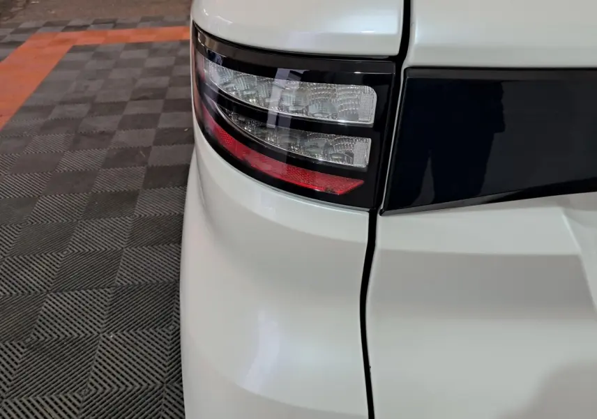 Gros plan sur le feu arrière gauche blanc de l'AIXAM AMBITION 0.5 CITY COUPE GTI 2026 avec bande noire distinctive.