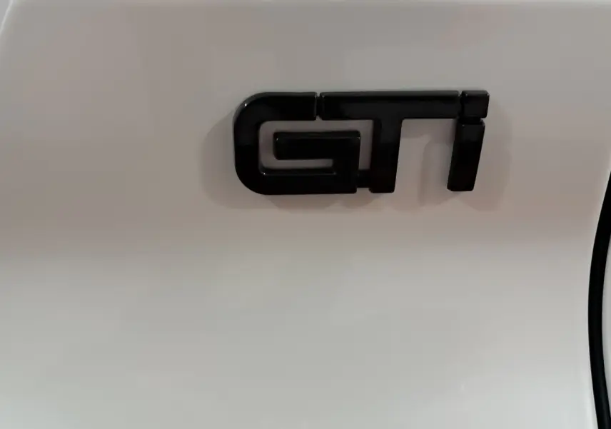 Gros plan sur l’inscription GTI noire sur la carrosserie blanche d’une Aixam Ambition 0.5 City Coupe 2026.