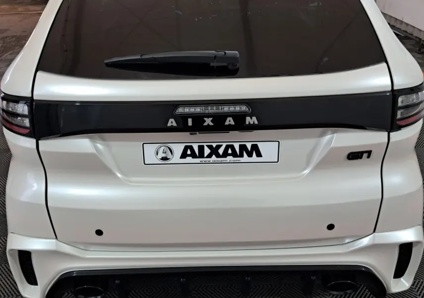 Vue arrière d'une AIXAM Ambition 0.5 City Coupe GTI blanche avec logo GTI et bande noire distinctive.
