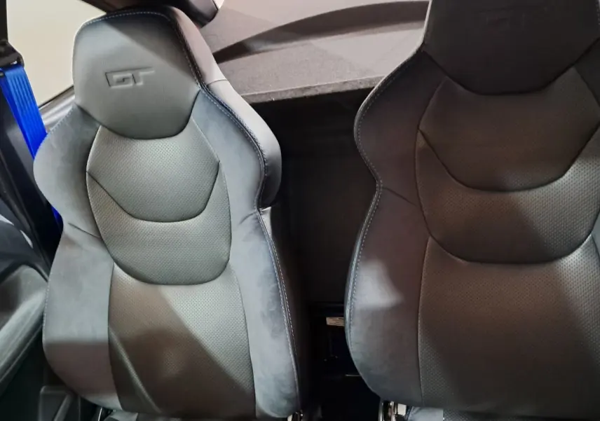 Gros plan sur les sièges avant noirs avec logo GT embossé, intérieur sportif de l'AIXAM AMBITION 0.5 CITY COUPE GTI.