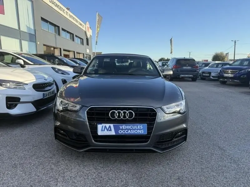 Vue de face d'une Audi A5 Cabriolet gris métal 2016 avec calandre S-Line et plaque "Véhicules Occasions".