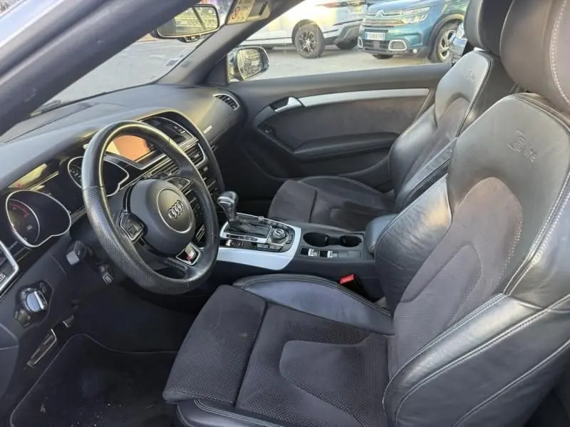 Intérieur côté conducteur de l'Audi A5 Cabriolet gris métal 2016, sièges S-Line en cuir noir et console centrale avec boîte auto.