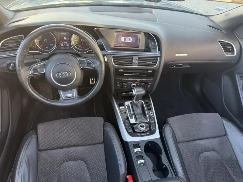 Vue intérieure de l’Audi A5 Cabriolet 2016 gris métal, tableau de bord et console centrale avec volant multifonction S-Line.