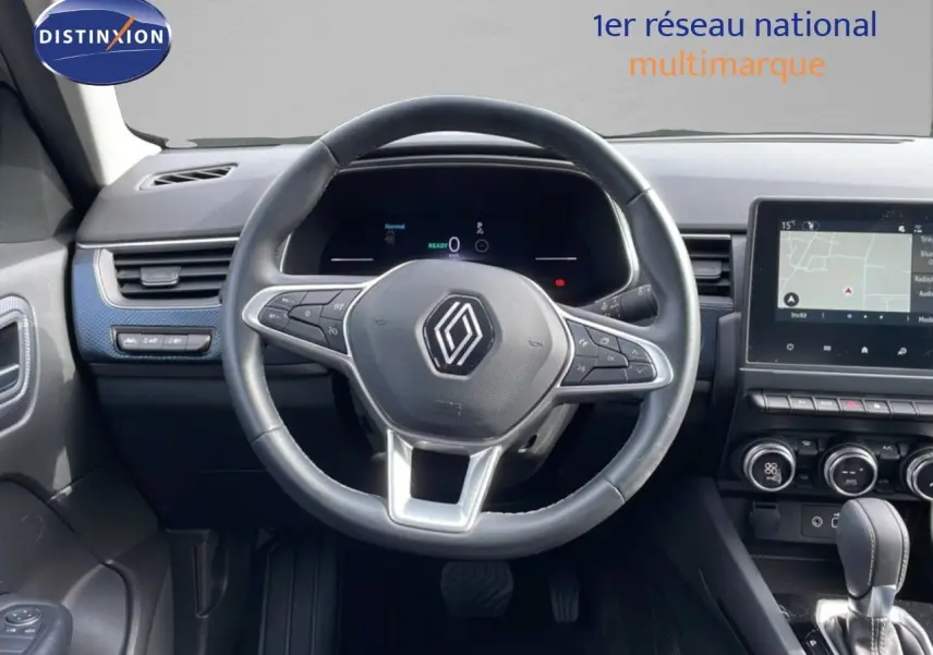 Vue intérieure centrée sur le volant noir du Renault Arkana 2024 avec tableau de bord digital et écran tactile.