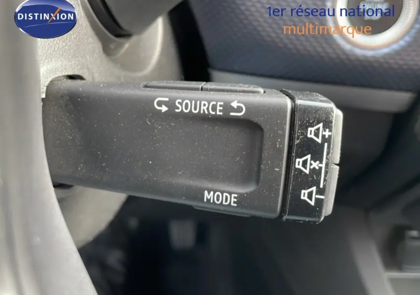 Gros plan sur la commande au volant du Renault Arkana 2024, boutons source et mode visibles sur fond intérieur noir.
