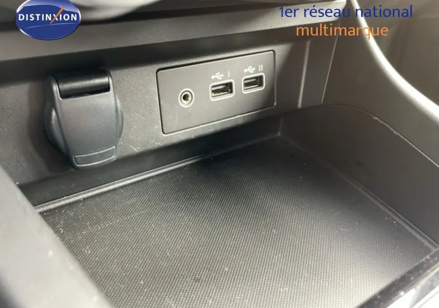 Vue rapprochée de la console centrale noire du Renault Arkana 2024 montrant les ports USB et prise auxiliaire.