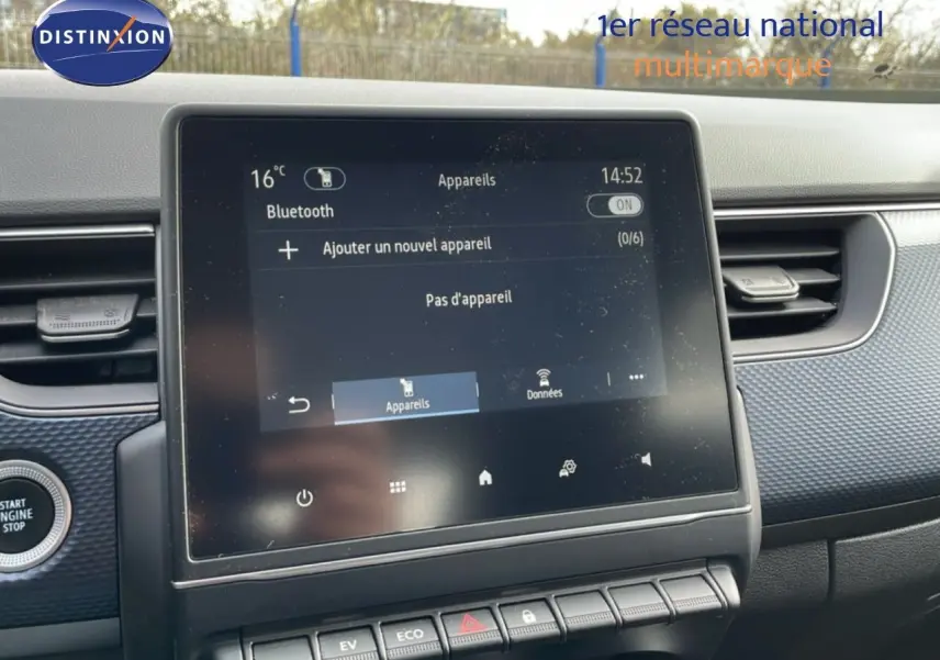 Écran tactile central du tableau de bord de la Renault Arkana 2024, avec interface Bluetooth et boutons de commande en dessous.