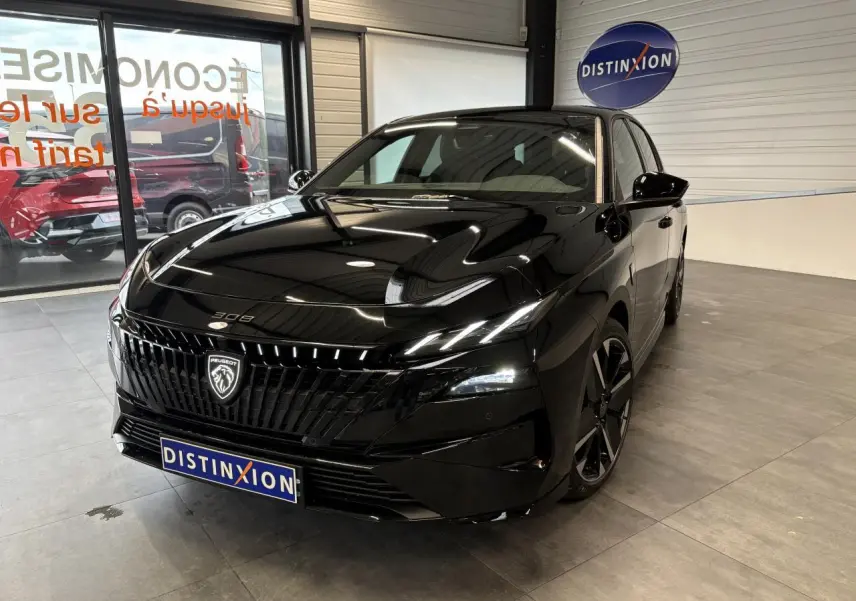 Peugeot 308 noir métallisé vue 3/4 avant droit en intérieur avec calandre noire et jantes alliage bi-ton.