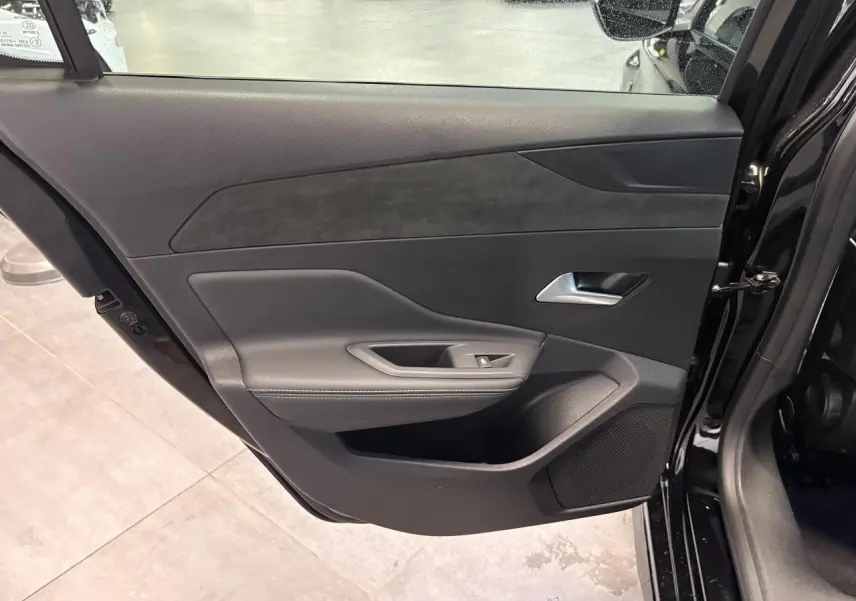 Vue intérieure de la porte arrière droite noire métallisée de la Peugeot 308 GT avec habillage noir et surpiqûres grises.