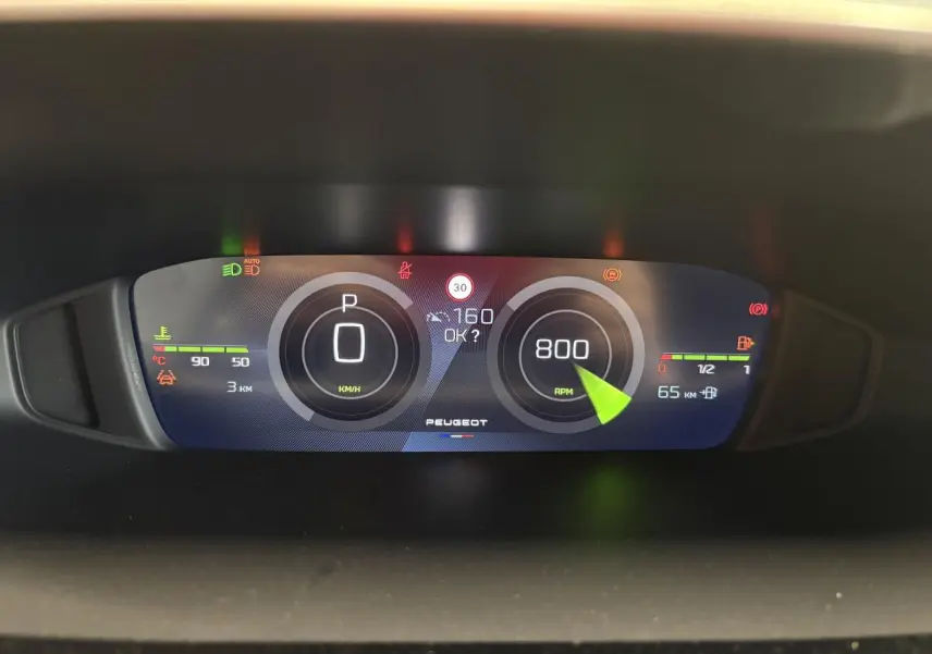 Tableau de bord numérique Peugeot 308 2026 affichant vitesse, régime moteur et jauges, vue frontale rapprochée.
